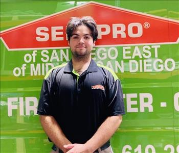 Man standing in front of green background with SERVPRO logo.